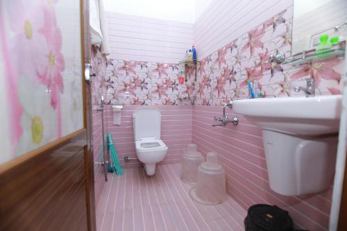 une salle de bains rose avec lavabo et toilettes. dans l'établissement Natureland Homestay, à Kottayam