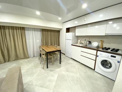 a kitchen with a table and a washing machine at GSS - B Apartment in Tbilisi City