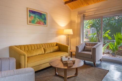 a living room with a couch and a chair at LaRiSa Resort & Spa, Ashwem in Mandrem