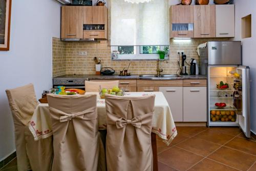 y cocina con mesa, sillas y nevera. en Cottage home at South Chania, en Grigorianá