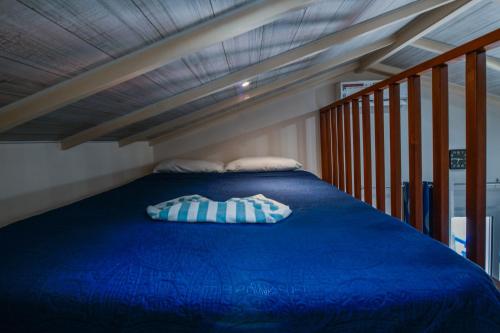 a bed with a blue comforter and pillows on it at Boutique Hotel Swiss Paradise Aruba Villas and Suites in Palm-Eagle Beach
