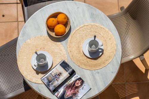 einen Tisch mit zwei Körben Orangen und eine Zeitschrift in der Unterkunft Apartamentos Marcelino - Formentera Break in Es Pujols