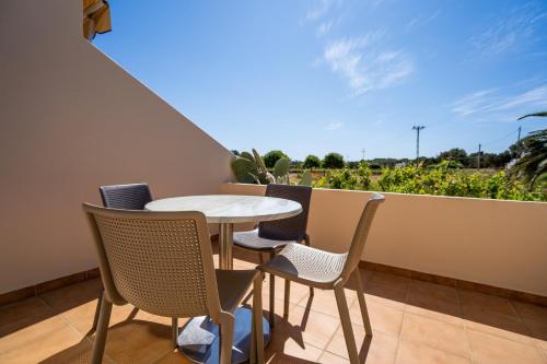 einen Tisch und Stühle auf einem Balkon mit Aussicht in der Unterkunft Apartamentos Marcelino - Formentera Break in Es Pujols