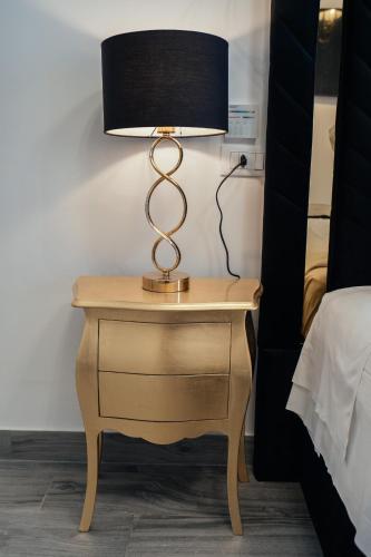 a lamp on a nightstand next to a bed at Imperial Rhome Guest House in Rome