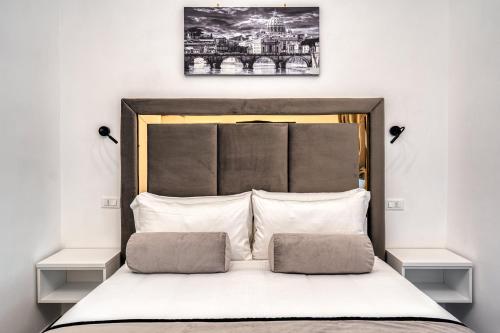 a bed with a black and white picture above it at Imperial Rhome Guest House in Rome