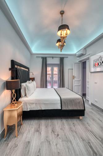a bedroom with a large bed and a chandelier at Imperial Rhome Guest House in Rome