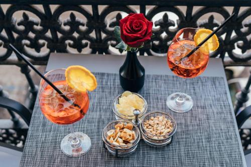 a table with three cocktails and bowls of snacks at Imperial Rhome Guest House in Rome