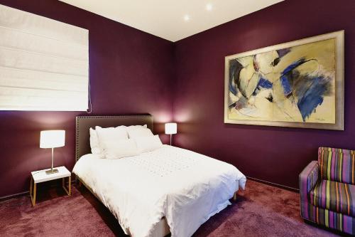 a bedroom with a white bed and a purple wall at Maison d'hôtes Bordeaux Centre Le Patio de l'Intendance in Bordeaux