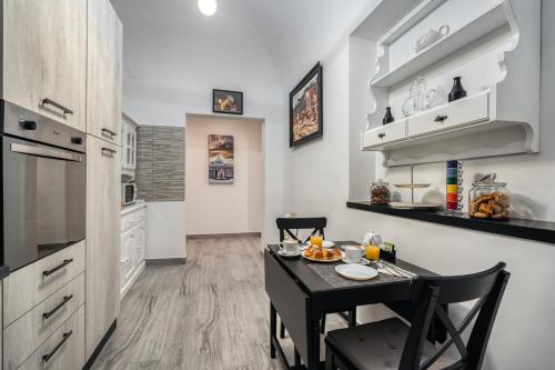 a kitchen with a small black table and chairs at Imperial Rhome Guest House in Rome