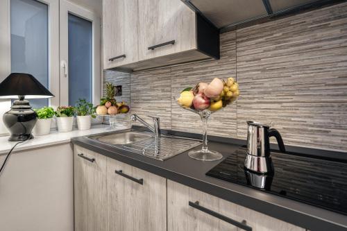 a kitchen with a sink and a bowl of fruit at Imperial Rhome Guest House in Rome