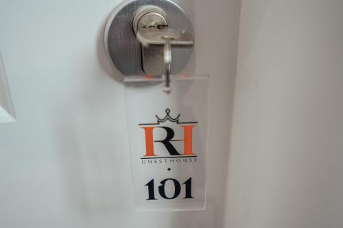 a toilet paper dispenser with a sign on a wall at Imperial Rhome Guest House in Rome