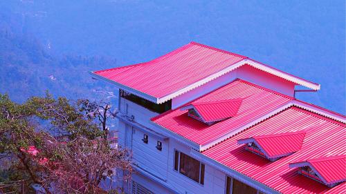 a building with a red roof on top of it at ShriGo Hotel Gangtok in Gangtok