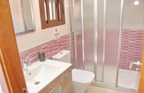 een badkamer met een douche, een toilet en een wastafel bij Chalet Sultan con piscina in Conil de la Frontera