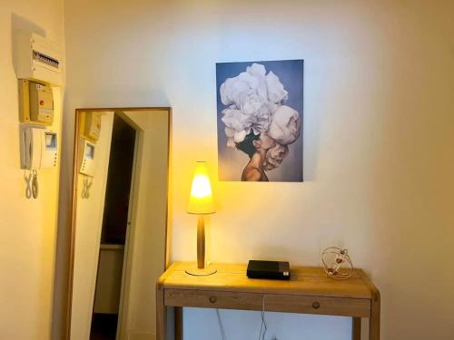 une lampe assise sur une table à côté d'un miroir dans l'établissement Champs Élysées-Belle terrasse, luxueux appartement, à Paris