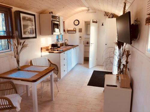 una cucina con un tavolo e una sala da pranzo di Zirkuswagen mit Outdoor Whirlpool und Garten a Petershagen