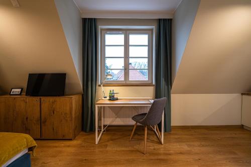 a bedroom with a desk and a window and a bed at Villa Bałtycka in Gdańsk