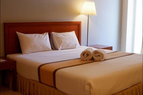 a bedroom with a bed with two towels on it at Phromsuk Hotel Ayutthaya in Phra Nakhon Si Ayutthaya