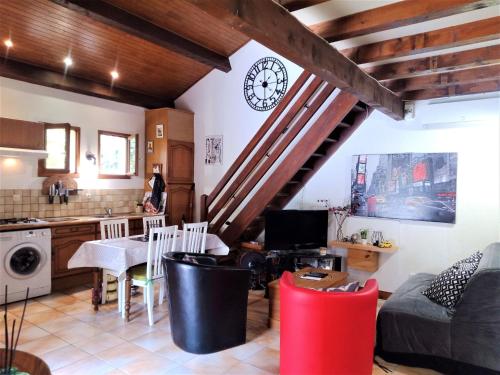 uma cozinha e sala de estar com um relógio na parede em Quiet holiday home with large pool em Saint-Martin-le-Redon