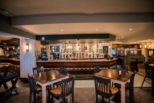 a restaurant with tables and chairs and a bar at Cat & Lion Country Pub and Hotel in Warrington
