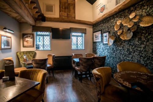a restaurant with chairs and tables in a room at Cat & Lion Country Pub and Hotel in Warrington