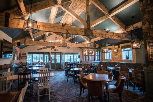 a dining room with wooden tables and chairs at Cat & Lion Country Pub and Hotel in Warrington