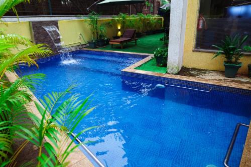 a large blue swimming pool next to a building at Trevon Hotels & Resorts Goa in Goa Velha