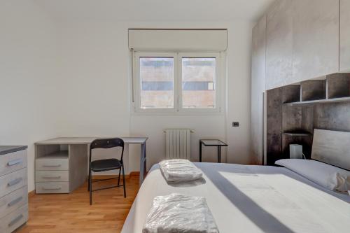 1 dormitorio con cama, escritorio y silla en Splendida terrazza su Arcimboldi - Milano Bicocca, en Milán