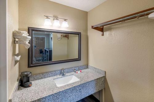 uma casa de banho com um lavatório e um espelho em Super 8 by Wyndham Tulsa/Arpt/St Fairgrounds em Tulsa