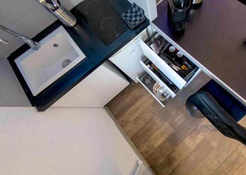 an overhead view of a small kitchen with a sink at Appart'Hôtel de la Gare - Cocooning in Montbéliard