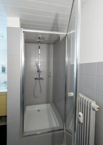a shower with a glass door in a bathroom at Appart'Hôtel de la Gare - Cocooning in Montbéliard