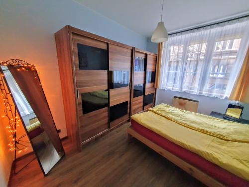 1 dormitorio con 1 cama y un gran armario de madera en Basic, quiet apartment close to Main Square, en Cracovia
