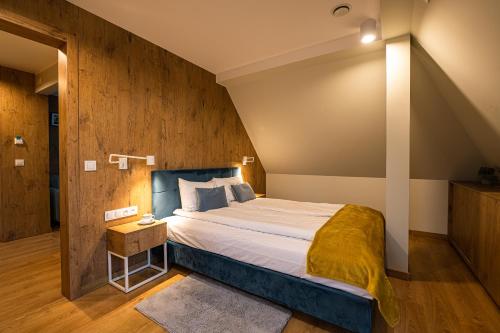 a bedroom with a large bed with a wooden wall at Villa Bałtycka in Gdańsk