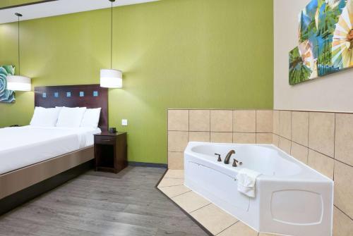 a hotel room with a bed and a bath tub at La Quinta by Wyndham Dallas Grand Prairie South in Grand Prairie