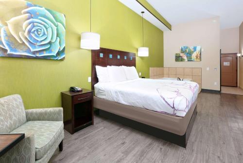 a bedroom with a bed and a couch and a chair at La Quinta by Wyndham Dallas Grand Prairie South in Grand Prairie