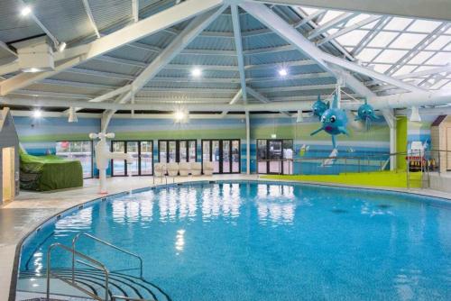 a large swimming pool in a building with a ceiling at Littlesea haven Rachel’s retreat in Wyke Regis