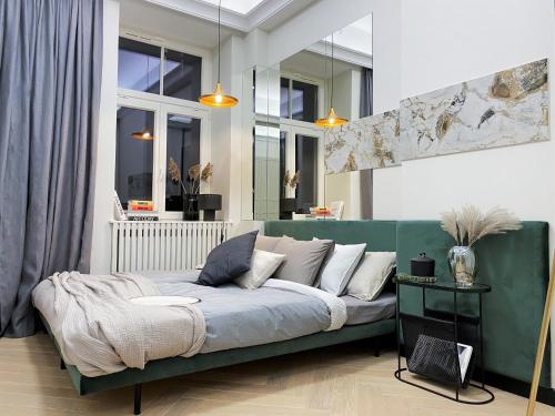 salon z zieloną kanapą w pokoju z oknami w obiekcie AK Apartments w Warszawie