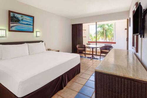 a hotel room with a bed and a table at Cozumel Hotel & Resort Trademark Collection by Wyndham in Cozumel