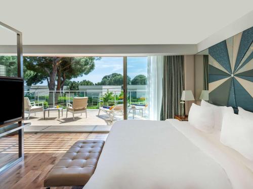 a hotel room with a large bed and a balcony at Club Prive By Rixos Belek in Belek