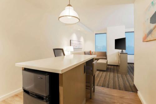 a room with a desk and a living room at Hyatt House Davis in Davis