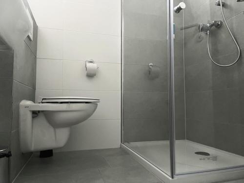 a bathroom with a shower and a toilet and a sink at Zentral gelegene Studios in Osnabrück