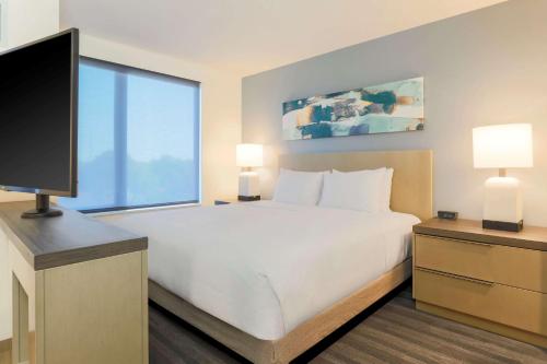 a bedroom with a large bed and a flat screen tv at Hyatt House Davis in Davis