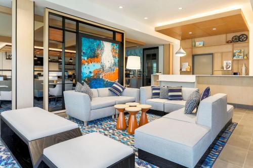 a living room with couches and tables and a kitchen at Hyatt House Davis in Davis