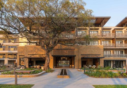 ein Gebäude mit einem Baum davor in der Unterkunft Radisson Blu Mosi-oa-Tunya Livingstone Resort in Livingstone