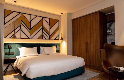 a bedroom with a large white bed and a window at Radisson Blu Aurum Hotel, Brasov in Braşov