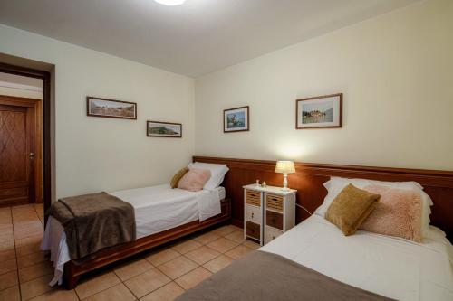 a bedroom with two beds and a lamp on a table at Charming & Luxury Villa Como Lake in Como