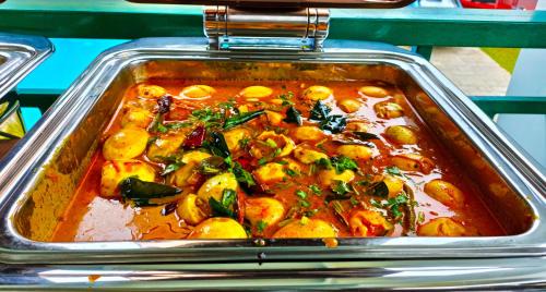 uma panela de metal com comida e ensopado dentro em Napier Heritage By Velvet Hotels em Cochin