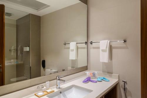 a bathroom with a sink and a large mirror at Radisson Resort Ras Al Khaimah Marjan Island in Ras al Khaimah