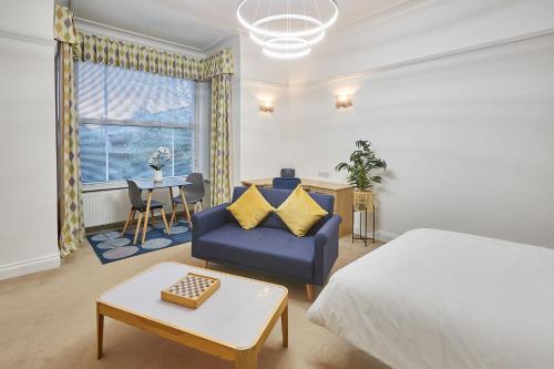 a bedroom with a bed and a couch and a table at Host & Stay - Thamesview in Staines