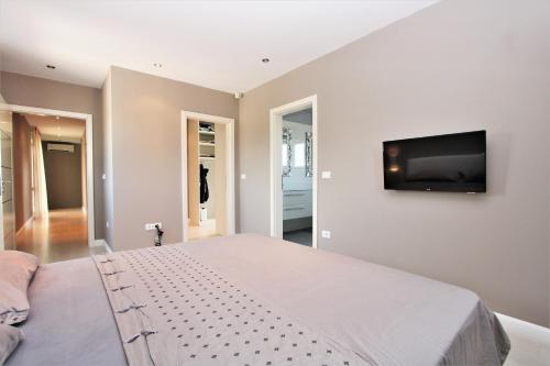 een slaapkamer met een groot bed en een flatscreen-tv bij Villa Alex Exclusive in Poreč