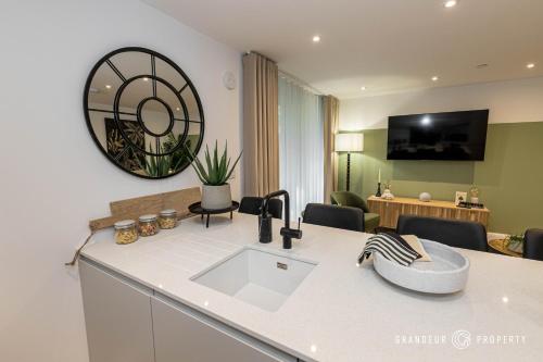 a kitchen with a sink and a living room at Aurora Heights by Grandeur Property in Poole